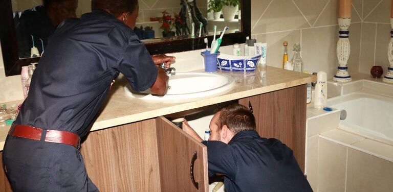 Plumbers Repairing a Bathroom Sink