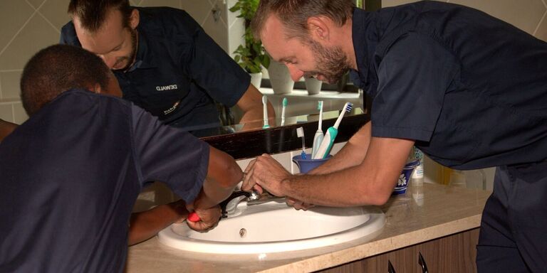 Team repairing bathroom sink tap – Alpha Plumbing