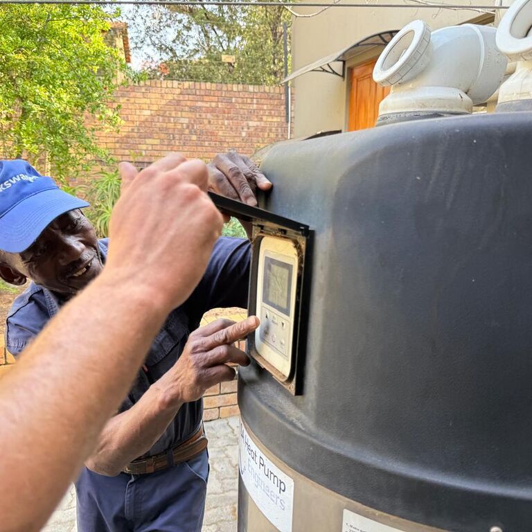 Alpha Plumbing technicians installing a heat pump system